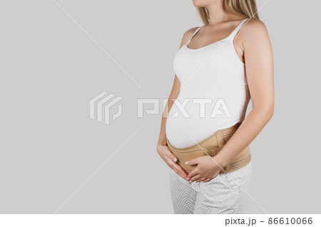 pregnant woman wearing maternity girdle. Isolated over white Stock