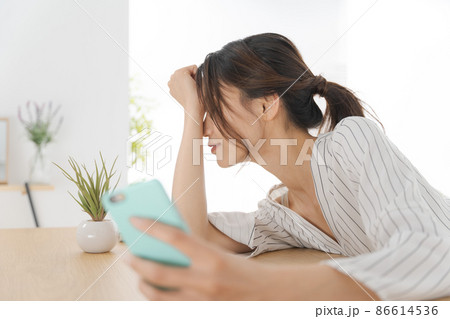 スマホを持つ女性　疲労　疲れ 86614536