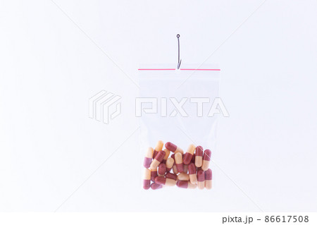 Colored Pills or Tablets Hanging in Small Ziplock Bag on a Fishing Hook 86617508