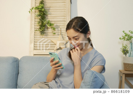 女性 スマホ リビング 夜 女性 スマホ リビング 夜 86618109
