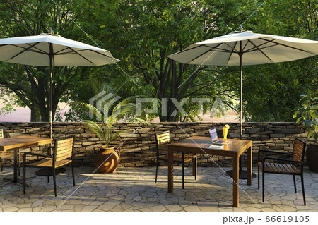 夕日が差し込むオープンテラスとノートPCが置かれたテーブル / リゾートワークのイメージ 86619105