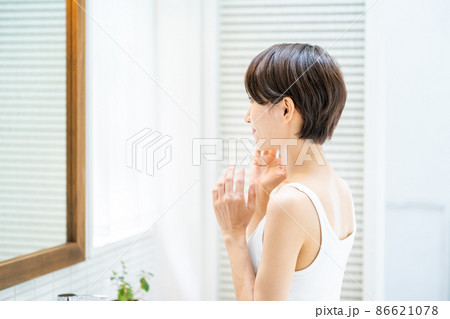 鏡の前で保湿を実感するミドル女性 86621078