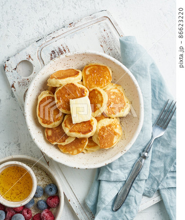 Pancakes cereal, tiny thin funny crumpet, children's food. Breakfast with drink, white table Pancakes cereal, tiny thin funny crumpet, children's food. Breakfast with drink, white table 86623220