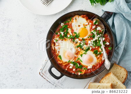 Shakshouka, eggs poached in sauce of tomatoes, olive oil. Mediterranean cuisine. Shakshouka, eggs poached in sauce of tomatoes, olive oil. Mediterranean cuisine. 86623222