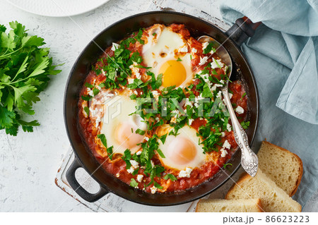 Shakshouka, eggs poached in sauce of tomatoes, olive oil. Mediterranean cuisine. 86623223