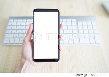 Unrecognizable person hold cell phone. View from behind, mockup with white phone display 86623382