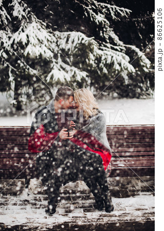Couple in love sitting on bench and smiling in 86625106