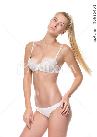 Young blonde woman in white underwear, studio - Stock Photo