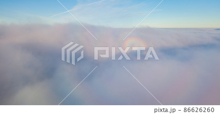 Aerial drone flight over the fog. There are thick clouds of fog below, the sun breaks through the clouds. Aerial drone flight over the fog. There are thick clouds of fog below, the sun breaks through the clouds. 86626260
