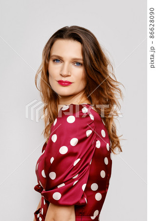 Portrait of young woman in dotted satin dress and polka dot tights 86628090