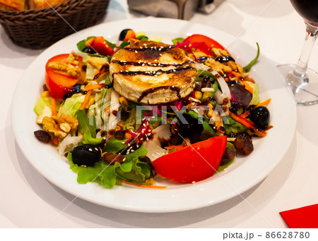 Vegetable salad with greens, tomatoes, grilled goat cheese, nuts Vegetable salad with greens, tomatoes, grilled goat cheese, nuts 86628780