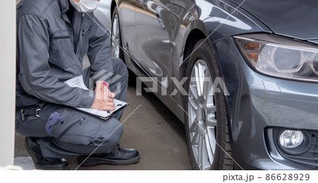 自動車をチェックする作業着の男性 86628929