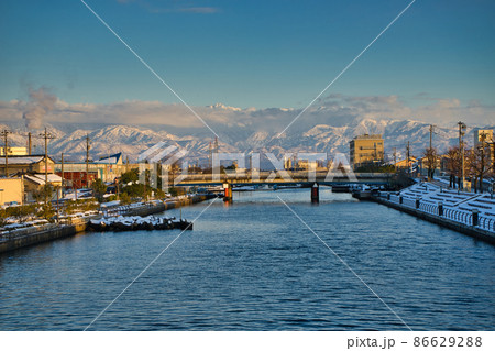 富山県富山市の岩瀬運河に架かる大漁橋から見た冬の夕方の立山連峰 剣岳 富山県富山市の岩瀬運河に架かる大漁橋から見た冬の夕方の立山連峰 剣岳 86629288