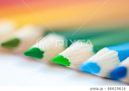 Set of wooden colored pencils- crayons on a white paper. Close up. Selective focus. Set of wooden colored pencils- crayons on a white paper. Close up. Selective focus. 86629616