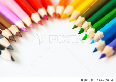 Set of wooden colored pencils on a white paper. Top view. 86629618
