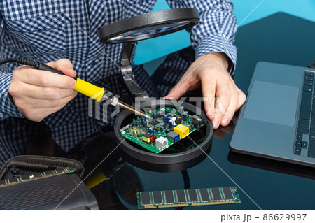 Cropped image of male hands working with motherboard isolated over blue background 86629997