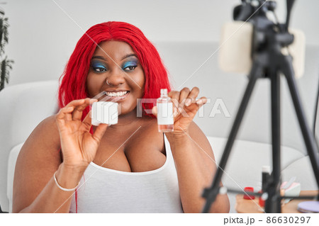 Woman celling cosmetics in internet while showing it to the smartphone camera with toothy smile 86630297
