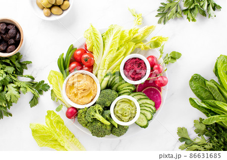 Fresh green veggie charcuterie platter with various dips 86631685