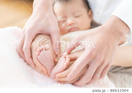 眠る赤ちゃん（新生児）と足に触れるママとパパの手 86632004