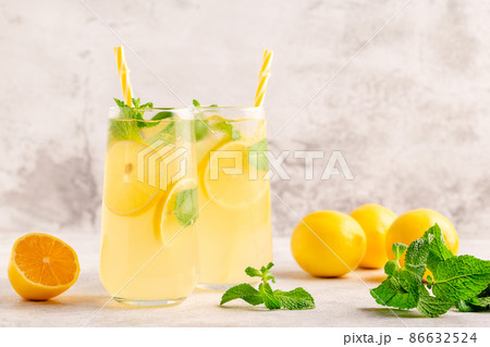 Lemonade with lemon, mint and ice cubes in glass Lemonade with lemon, mint and ice cubes in glass 86632524