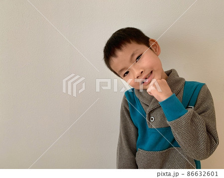 少しはにかみながら首を傾げるかわいい男の子 86632601