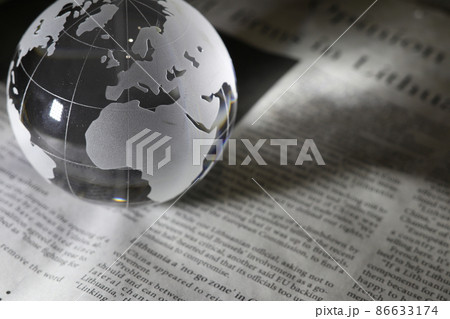 ガラスの地球儀と英字新聞　グローバルなニュースのイメージ 86633174