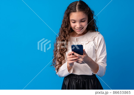 Little girl using mobile phone.against blue background 86633865