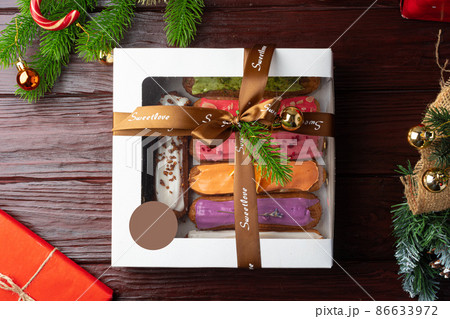 Box of colorful eclairs on Christmas background Box of colorful eclairs on Christmas background 86633972