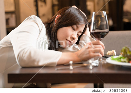飲食店で酔いつぶれ眠る女性 86635093
