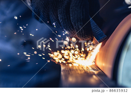 Closeup of Sparks that fly out when grinding metal details machine. Metallurgical Plant Closeup of Sparks that fly out when grinding metal details machine. Metallurgical Plant 86635932