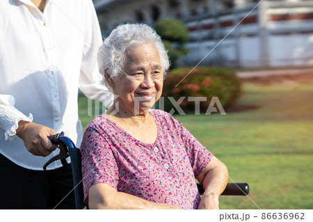 Caregiver help and care Asian senior or elderly old lady woman patient sitting on wheelchair in park, healthy strong medical concept. Caregiver help and care Asian senior or elderly old lady woman patient sitting on wheelchair in park, healthy strong medical concept. 86636962