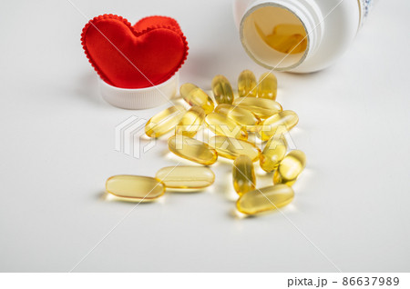 Gold fish oil isolated on white background with red hearts. Gold fish oil isolated on white background with red hearts. 86637989