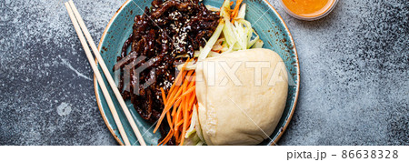 Chinese traditional dish sweet and sour deep fried glazed pork with vegetables and steamed bao bun Chinese traditional dish sweet and sour deep fried glazed pork with vegetables and steamed bao bun 86638328