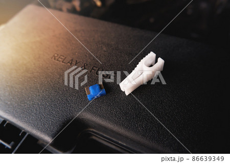 The spare fuse and the fuse clip tool on the car fuse box, automotive electronics part concept The spare fuse and the fuse clip tool on the car fuse box, automotive electronics part concept 86639349