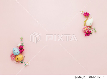 Easter holiday pink mockup background. Top view from above to different colorful Easter eggs, flowers, picture frame border. Card with copy space to place text. Minimal flat lay. High quality photo 86640703
