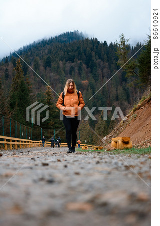 Walking on forest roads, a man walking alone on a forest road on the background of the mountain top with fog. 86640924