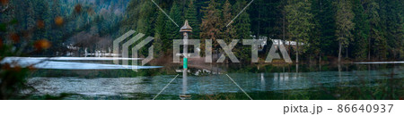 Alpine lake Synevyr, wooden statues near the lake, a tourist place in Ukraine, ice on the lake. Alpine lake Synevyr, wooden statues near the lake, a tourist place in Ukraine, ice on the lake. 86640937