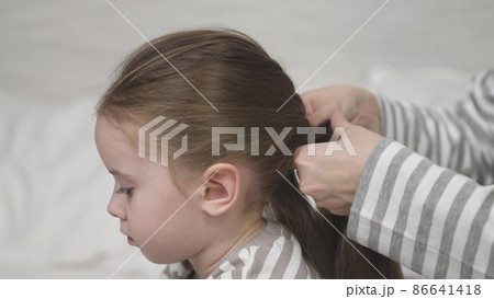 Mother braids daughter brunette long hair into hairstyle Mother braids daughter brunette long hair into hairstyle 86641418