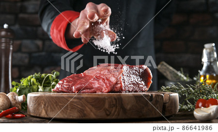 Close-up of falling salt and pepper on tasty beef steak Close-up of falling salt and pepper on tasty beef steak 86641986