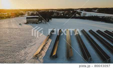 A vibrant winter sunrise at the abandoned old barn and solar panels in the field A vibrant winter sunrise at the abandoned old barn and solar panels in the field 86643097
