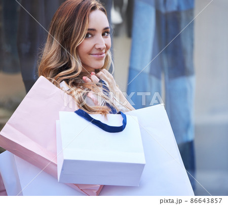 Scored some great deals today. Shot of a young woman holding her shopping bags. Scored some great deals today. Shot of a young woman holding her shopping bags. 86643857