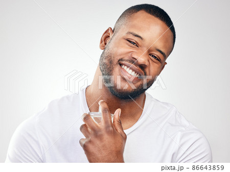 This scent compliments my personal style. Studio portrait of a handsome young man spraying perfume on himself against a white background. This scent compliments my personal style. Studio portrait of a handsome young man spraying perfume on himself against a white background. 86643859