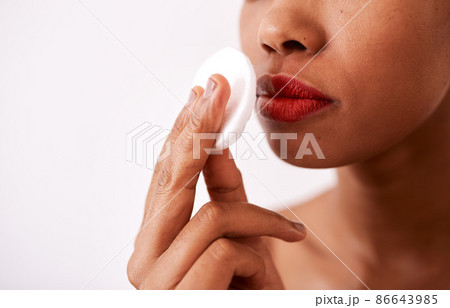 A cotton pad is gentle on your skin. Studio shot of an unrecognizable woman using a cotton pad to remove her lipstick. 86643985