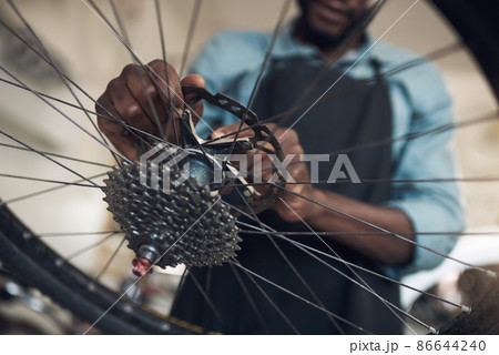 Youre almost ready for another generation of memories. Low angle shot of an unrecognizable man standing alone in his shop and repairing a bicycle wheel. 86644240