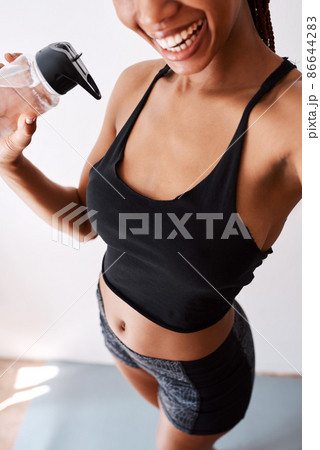 Hitting the gym feels good. Selfie view of a woman holding her water bottle while posing in her gym clothes. 86644283