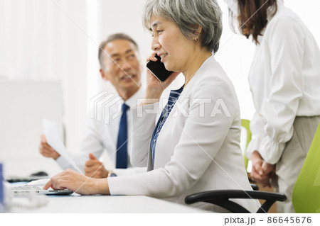 スマホで話す50代のキャリアウーマン スマホで話す50代のキャリアウーマン 86645676