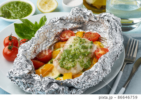 Foil pack dinner with white fish. Oven baked fillet of cod, pike perch with vegetables Foil pack dinner with white fish. Oven baked fillet of cod, pike perch with vegetables 86646759