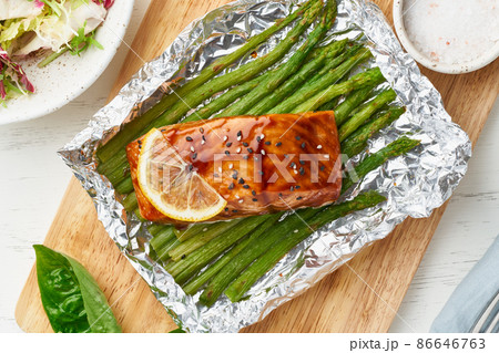 Foil pack dinner with red fish. Fillet of salmon with asparagus. Oven-baked hot dinner Foil pack dinner with red fish. Fillet of salmon with asparagus. Oven-baked hot dinner 86646763