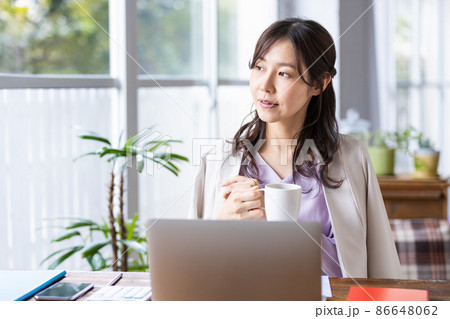 マグカップを持ったリモートワーク中の女性 86648062