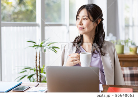 マグカップを持ったリモートワーク中の女性 86648063